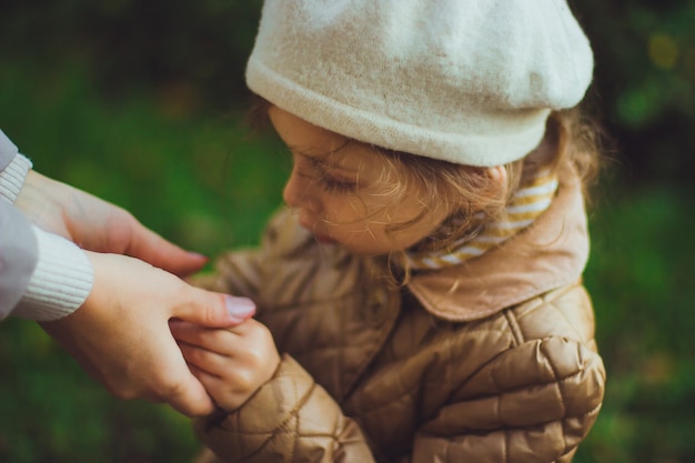 Mom holds hands of her daughter