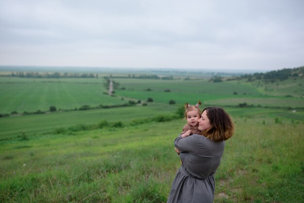 Mom holds her little daughter in her arms.