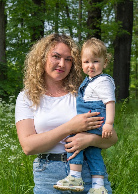 Mom holds a oneyearold fairhaired baby in her arms