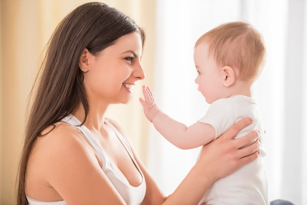 Mom holds a small cute baby in her arms.