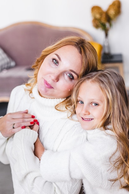 Photo mom hugs her daughter bright interior