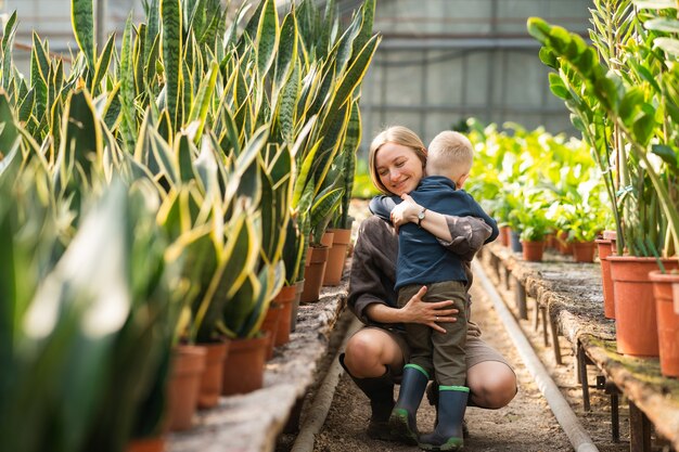 Mom hugs her son in the greenhouse