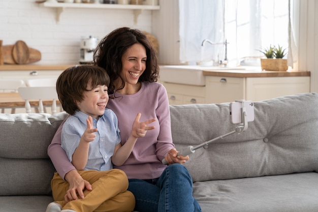 Mom and kid holding phone on selfie stick for video call