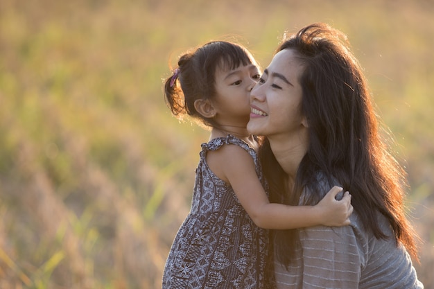 ママと子供の夕焼け空の下でキス