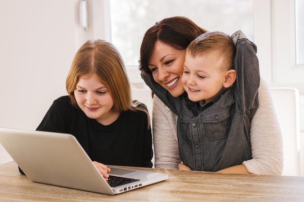 Mom and kids playing on computer at home