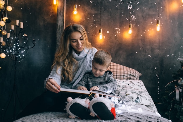 Mom and little boy reading a book in the room