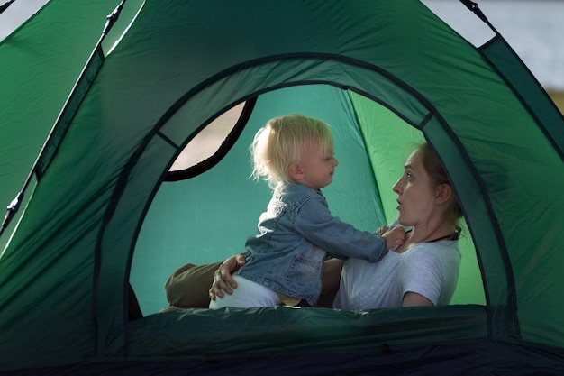 Mom and little child in tent in nature