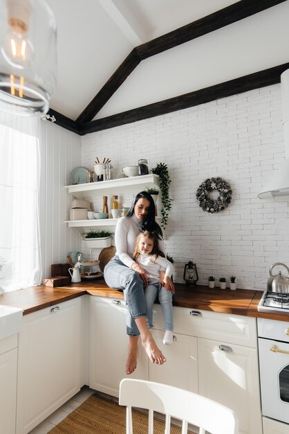 Mom and Little Daughter cook in the kitchen and play. Family, happiness.