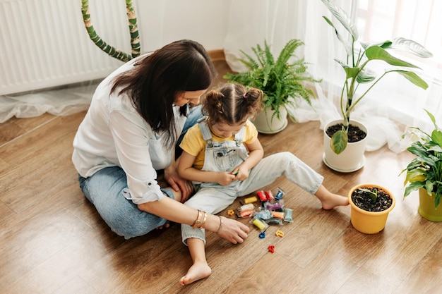 mom and little daughter at home sculpt from plasticine and play together the concept of preschool