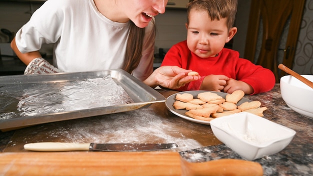 Photo mom and little son bake xmas cookies together