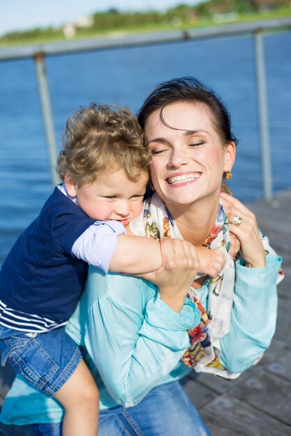 Mom and little son walk in the park and have fun on a sunny summer day