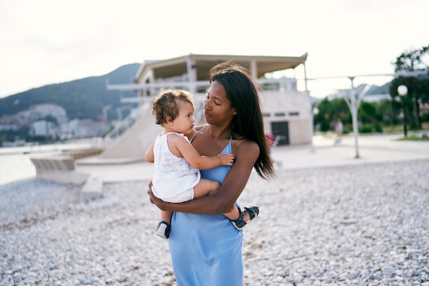 Mom looks at the little girl sitting in her arms