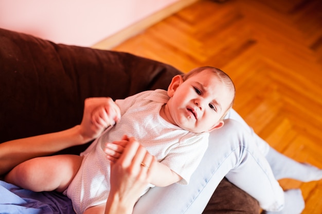 Mom makes massage a child who whimpers in pain