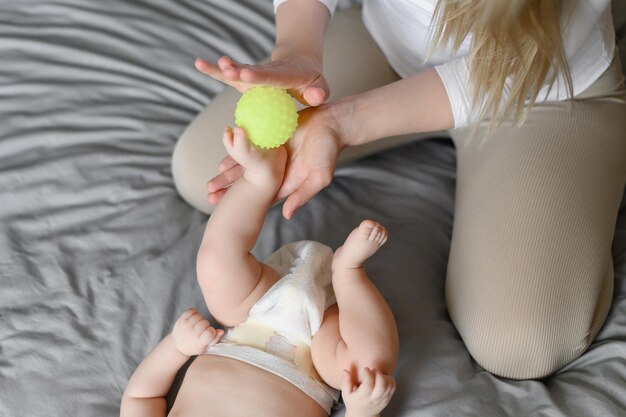 Mom massages the childs legs with a massage ball children massage nanny maternity leave massage ther