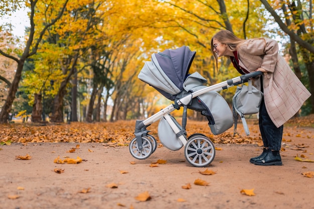 Mom playing with newborn baby in stroller