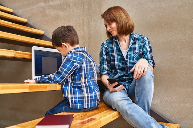 Mamma e figlio stanno facendo i compiti al computer