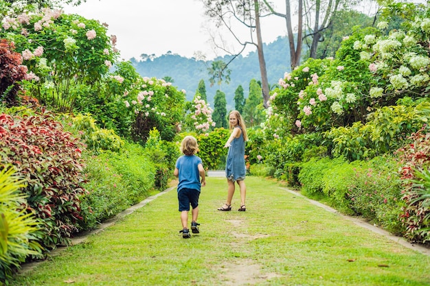 Mom and son are running around in the blooming garden. Happy family life style concept