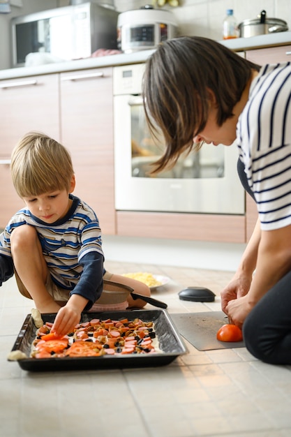 Mamma e figlio cucinano la pizza insieme