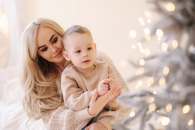 Mom and son decorate Christmas tree at home. Mood