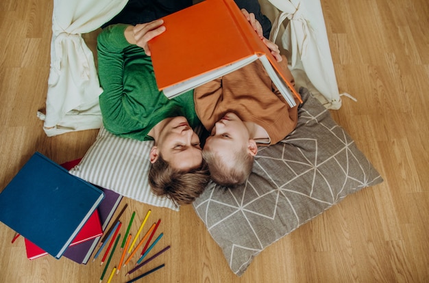 Photo mom son lie together hut read book