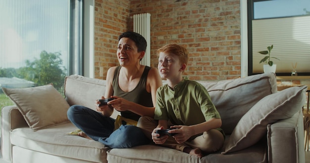 ママと息子がジョイスティックを使ってビデオゲームをしています