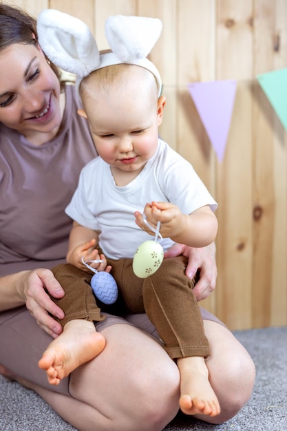 Mom and son play with Easter eggs Easter holiday rabbit ears