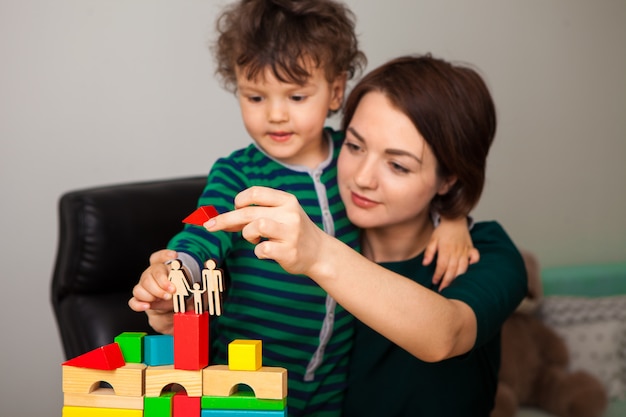 Mom and son playing together with wooden bricks