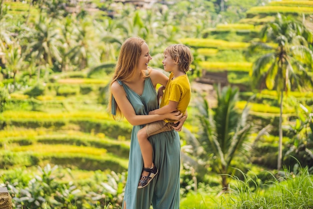 Mom and son on the rice field in the background of rice terraces Ubud Bali Indonesia Traveling with children concept Teaching children in practice