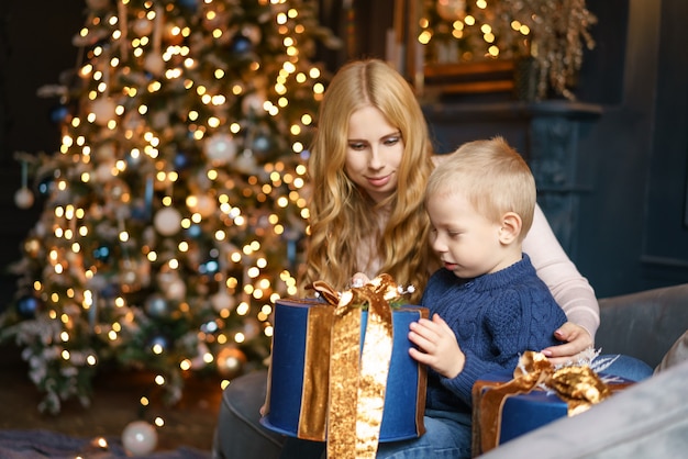 Mom and son sitting in the pose of a Christmas tree, holiday concept.