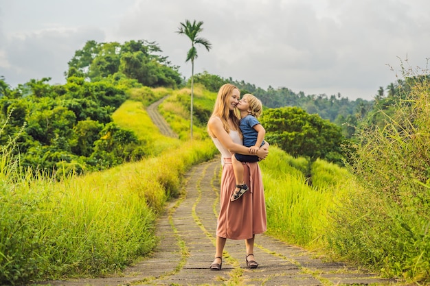 Mom and son tourists in Campuhan Ridge Walk , Scenic Green Valley in Ubud Bali. Traveling with children concept