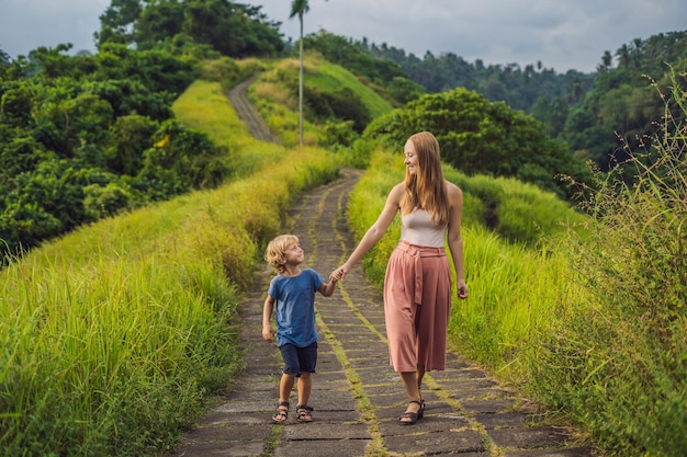 Mom and son tourists in Campuhan Ridge Walk , Scenic Green Valley in Ubud Bali. Traveling with children concept.