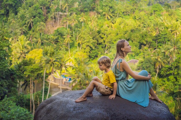 Photo mom and son tourists on a stone over the jungle traveling with kids concept what to do with children child friendly place