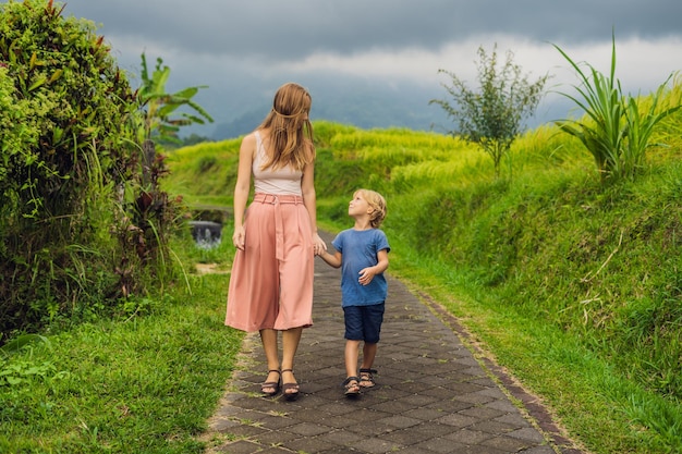 Mom and son travelers on Beautiful Jatiluwih Rice Terraces against the background of famous volcanoes in Bali, Indonesia Traveling with children concept