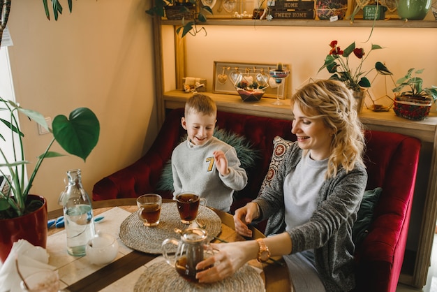 Mom and son with flowers in caffe. Son give flowers to mother. cute family. International women`s day, 8 march celebrating