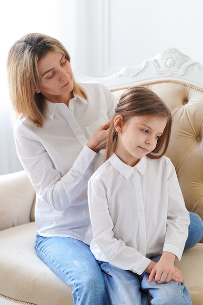 Photo mom straightens her daughter's hair.