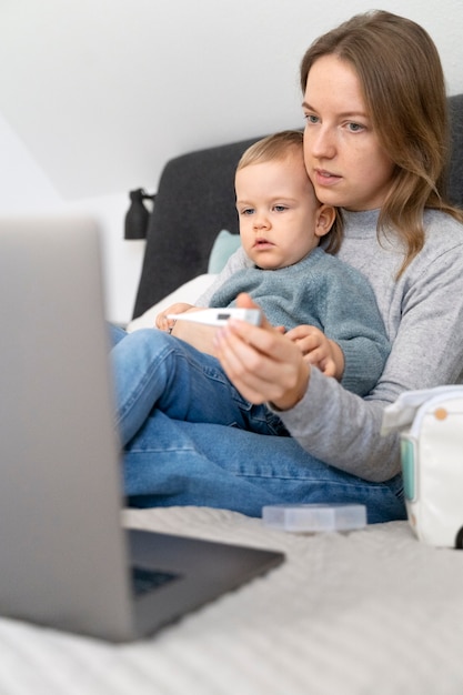 Photo mom taking care of her child and teleconsulting with doctor