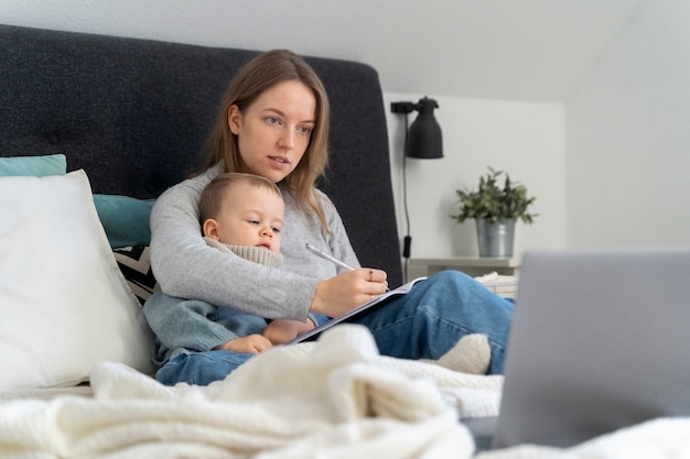 Foto mamma si prende cura di suo figlio e si teleconsulta con il medico