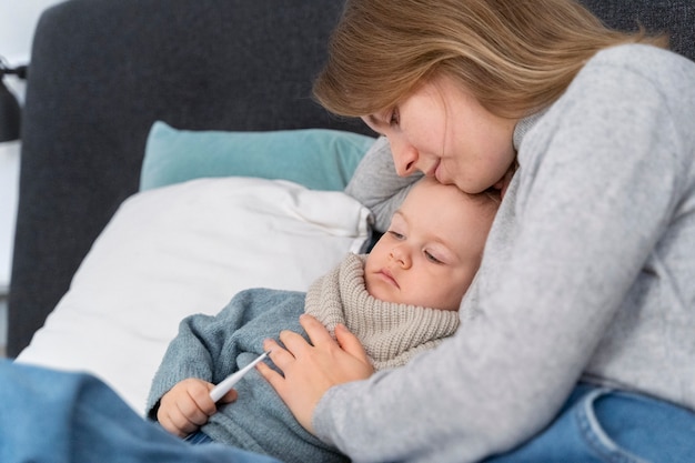 Photo mom taking care of her child and teleconsulting with doctor