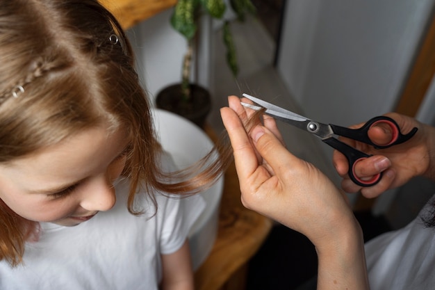 Mom taking care of  her daughter's hair