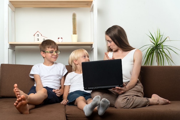 Mom teaches two sons the rules for using Internet resources. Computer security.