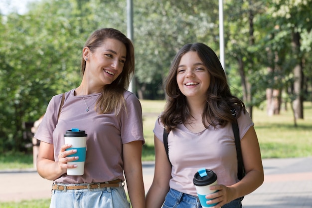 Mom and teenage daughter have fun on a walk in the park. Happy family concept