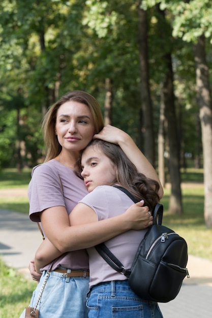 Mom and teenage daughter have fun on a walk in the park. Happy family concept