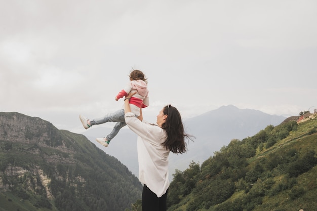 Mom travels through the mountains with her young child mom throws the child and catches baby with pa...