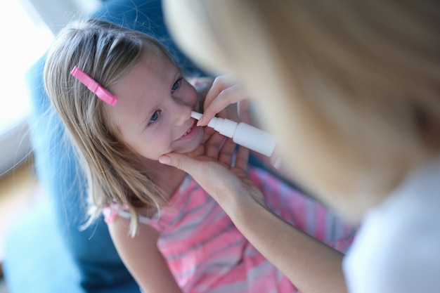 Mom treats her daughter for allergies, nasal spray