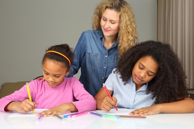 Photo mom watches as her daughter drawing with crayons