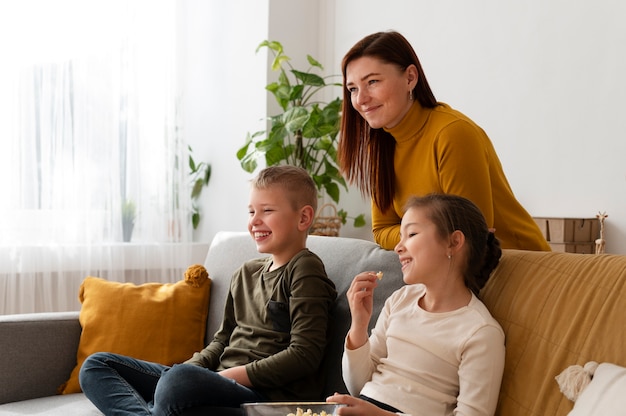 Foto mamma che guarda la televisione con i suoi figli