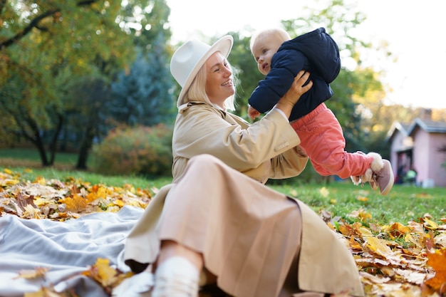 Mom with baby in hands at the autumn park