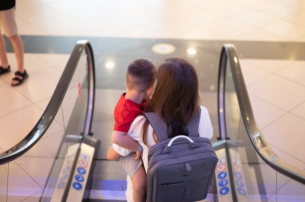 Mom with a child in her arms, descend on an escalator.