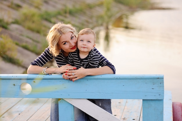 Mom with a child sitting on a wooden bridge