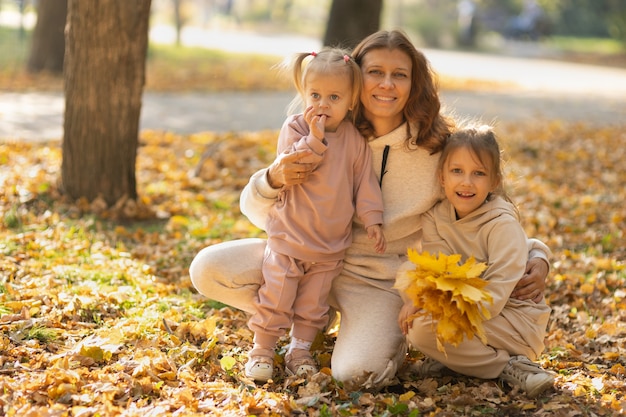 Mom with daughters in the park in autumn